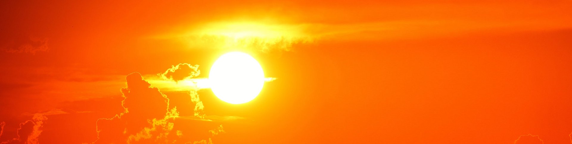 Hell leuchtende Sonne am orange-roten Himmel.